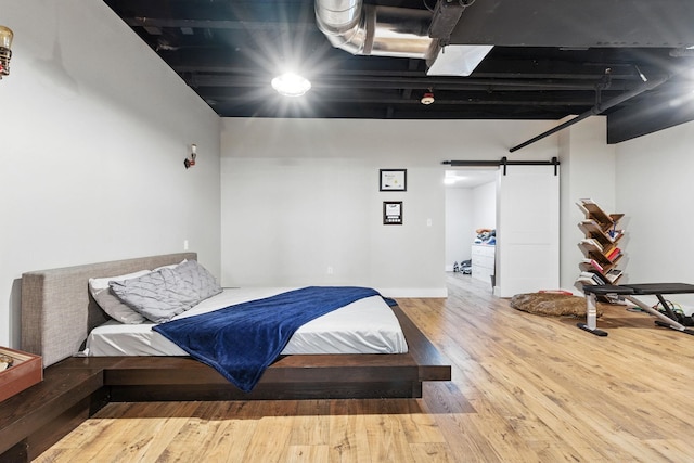 315 W Riverside Ave Unit 101, Spokane, WA 99201 - bedroom featuring a barn door and wood finished floors
