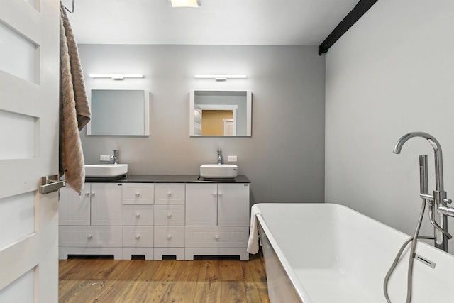 315 W Riverside Ave Unit 101, Spokane, WA 99201 - full bathroom with double vanity, a freestanding bath, and wood finished floors