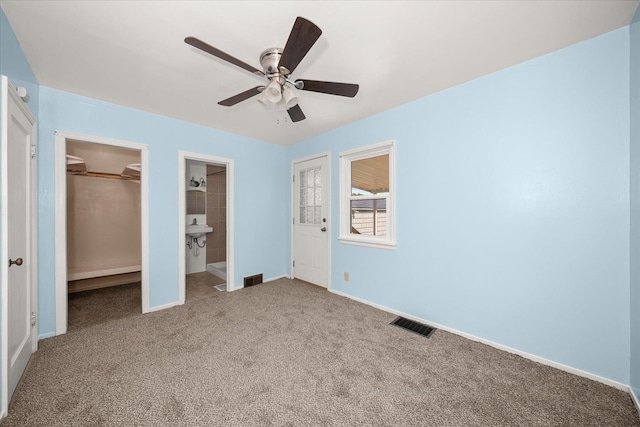 2608 E Heroy Ave, Spokane, WA 99207 - unfurnished bedroom featuring carpet flooring, a walk in closet, and a ceiling fan