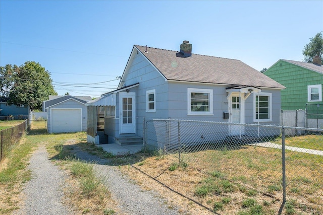 2608 E Heroy Ave, Spokane, WA 99207 - bungalow-style home featuring driveway, a shingled roof, a chimney, and an outdoor structure