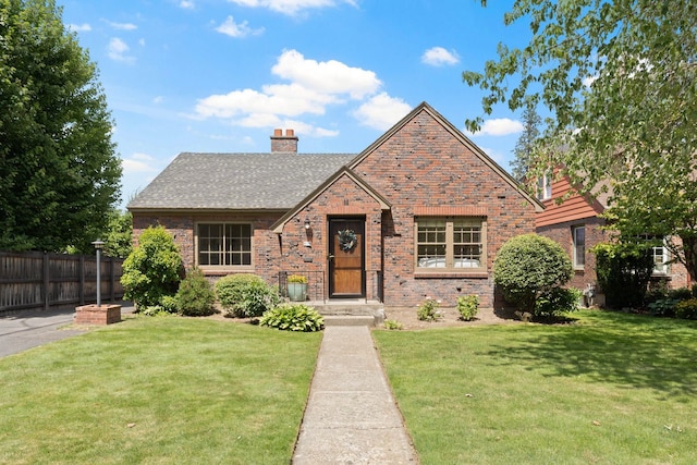 818 W 27th Ave, Spokane, WA 99203 - tudor house with a chimney, a shingled roof, and brick siding