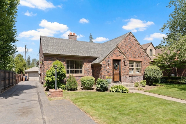 818 W 27th Ave, Spokane, WA 99203 - tudor home featuring a chimney, a detached garage, brick siding, and roof with shingles
