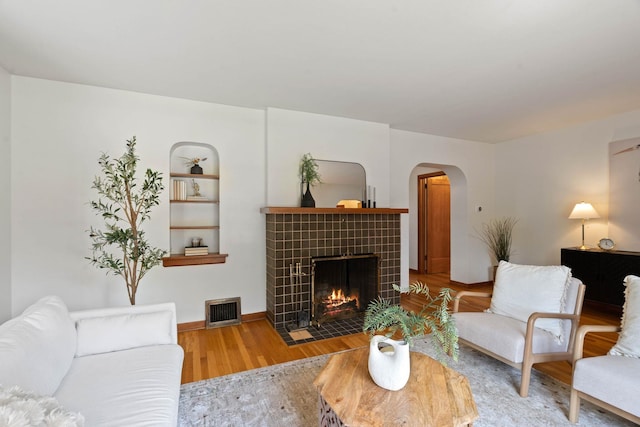 818 W 27th Ave, Spokane, WA 99203 - living area with wood finished floors, a fireplace, and arched walkways