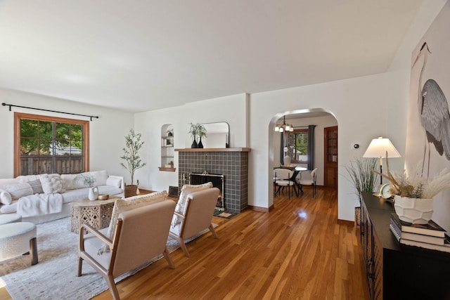 818 W 27th Ave, Spokane, WA 99203 - living room featuring arched walkways, light wood-style floors, a chandelier, and a fireplace