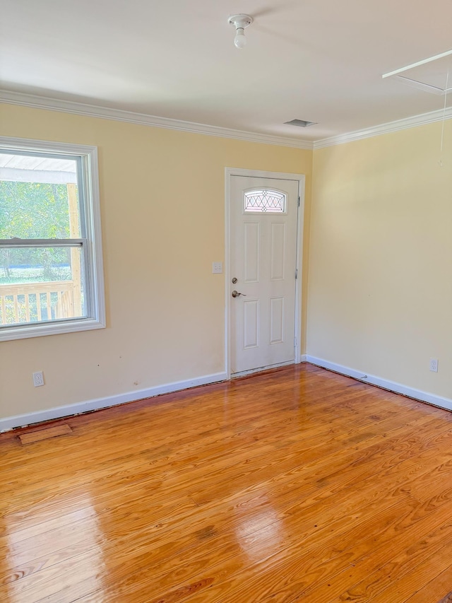 entrance foyer with ornamental molding and light wood-type flooring