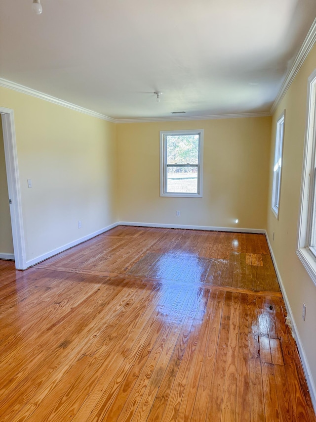 empty room featuring ornamental molding and light hardwood / wood-style flooring