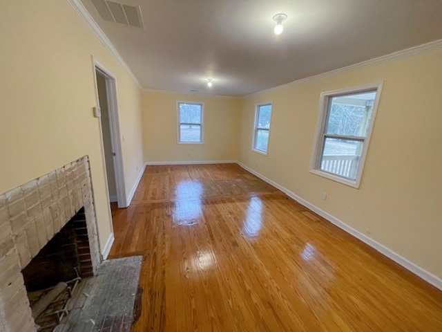 unfurnished living room featuring a brick fireplace, hardwood / wood-style flooring, and ornamental molding