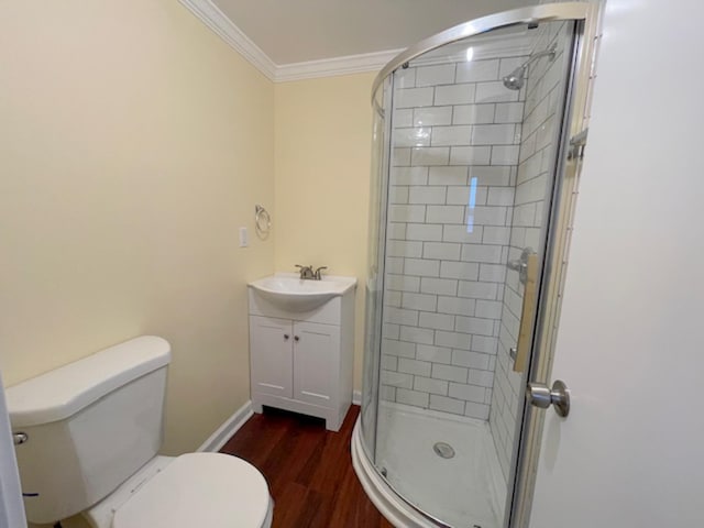 bathroom with hardwood / wood-style flooring, a shower with door, vanity, ornamental molding, and toilet