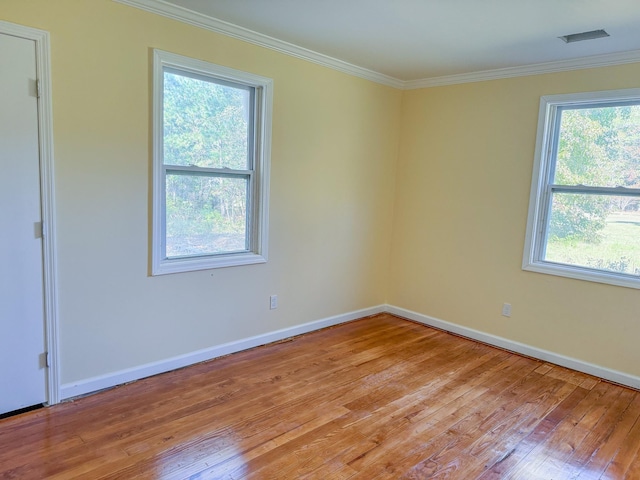 empty room featuring crown molding and light wood-type flooring