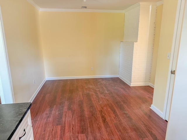 spare room with crown molding and dark wood-type flooring