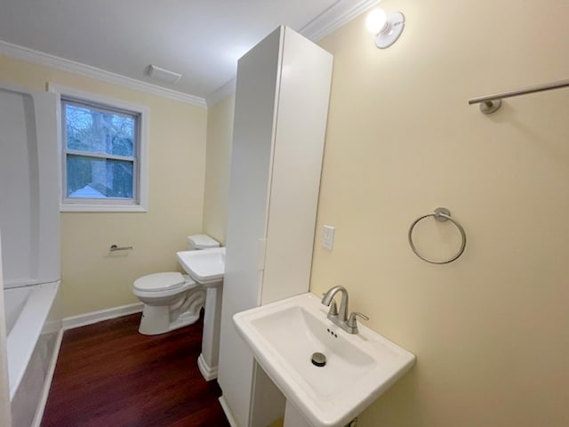 bathroom featuring sink, hardwood / wood-style flooring, ornamental molding, and toilet