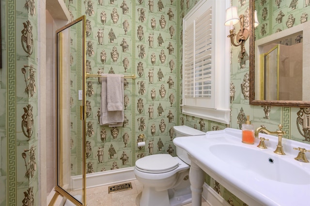 bathroom with tile patterned flooring, toilet, sink, and a shower with shower door