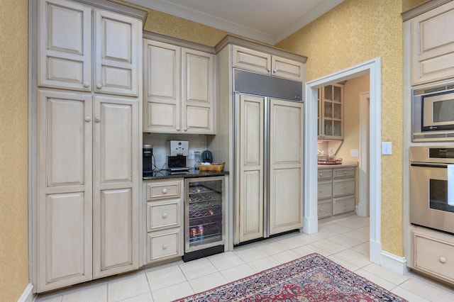 kitchen with built in appliances, wine cooler, ornamental molding, light tile patterned flooring, and cream cabinetry