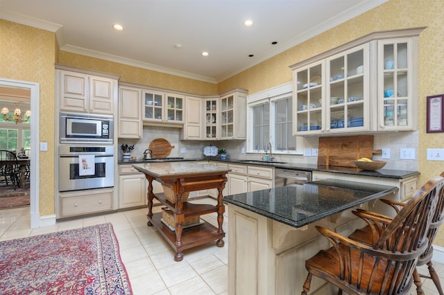 kitchen featuring sink, a center island, dark stone countertops, a kitchen breakfast bar, and stainless steel appliances