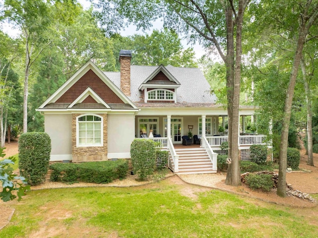 view of front of property featuring a front yard, french doors, and a porch