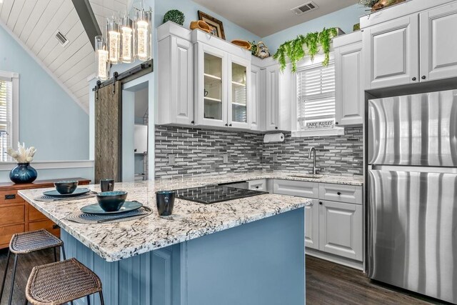 1611 Lighthouse Cir, Greensboro, GA 30642 - kitchen featuring visible vents, a kitchen bar, a barn door, a sink, and freestanding refrigerator