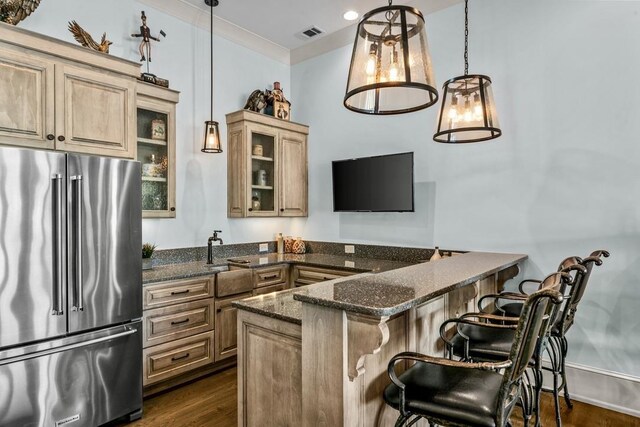 1611 Lighthouse Cir, Greensboro, GA 30642 - kitchen with high end fridge, a breakfast bar, dark wood-style floors, glass insert cabinets, and visible vents
