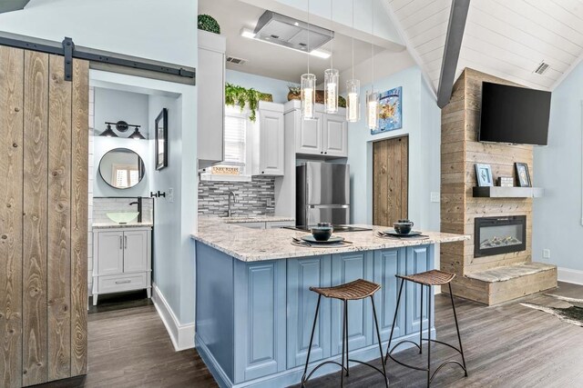 1611 Lighthouse Cir, Greensboro, GA 30642 - kitchen featuring backsplash, a sink, freestanding refrigerator, white cabinets, and a peninsula