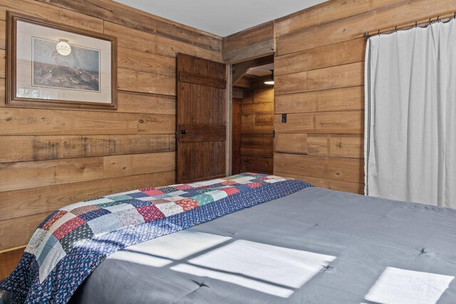 bedroom featuring wooden walls