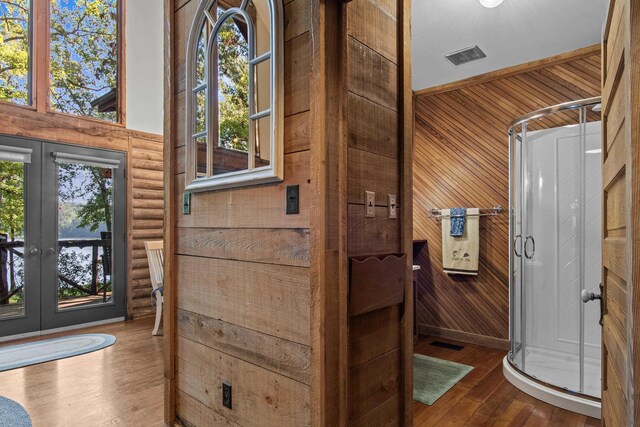 bathroom with hardwood / wood-style floors, french doors, and rustic walls