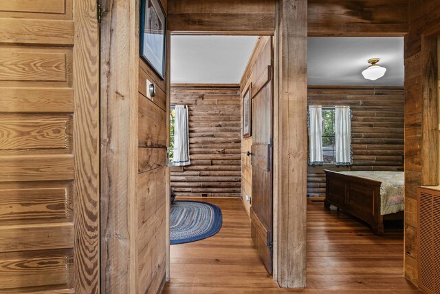 hall featuring hardwood / wood-style flooring and rustic walls