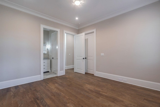 unfurnished bedroom with ensuite bath, crown molding, baseboards, and wood finished floors