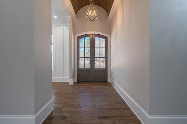 entrance foyer featuring arched walkways, dark wood-style flooring, baseboards, vaulted ceiling, and french doors