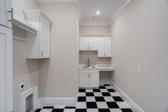 clothes washing area featuring crown molding, visible vents, a sink, baseboards, and tile patterned floors