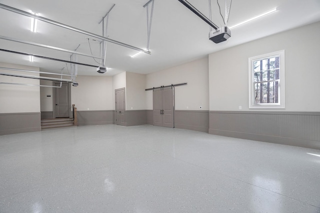 garage with a wainscoted wall and a garage door opener