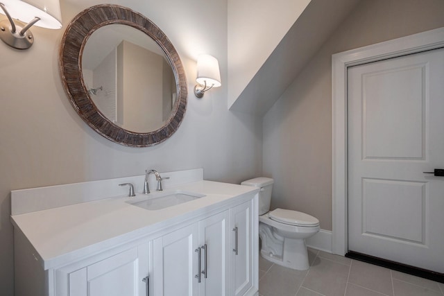 bathroom with toilet, tile patterned floors, vaulted ceiling, and vanity