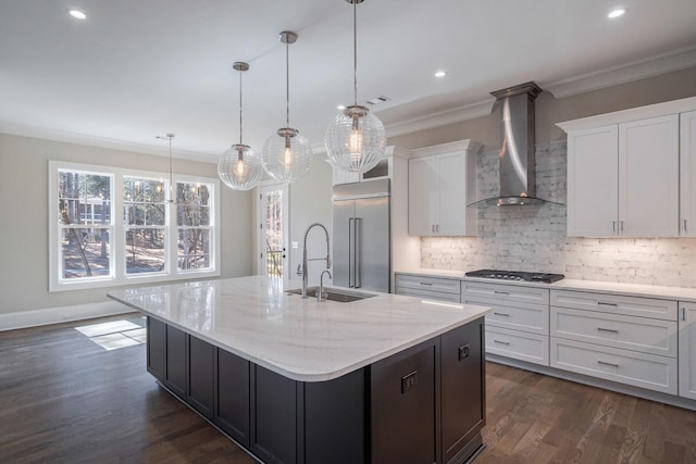 kitchen featuring ornamental molding, wall chimney range hood, appliances with stainless steel finishes, decorative backsplash, and dark wood-style floors