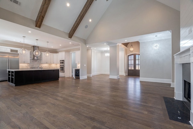 unfurnished living room featuring a fireplace with flush hearth, dark wood-type flooring, a sink, high vaulted ceiling, and beam ceiling