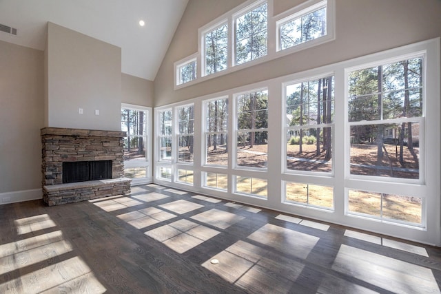 living room with high vaulted ceiling, a stone fireplace, recessed lighting, wood finished floors, and visible vents