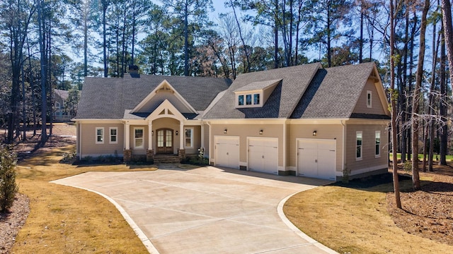 view of front of house with an attached garage, driveway, and french doors