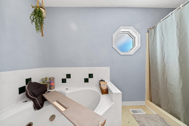 bathroom featuring tile patterned floors, visible vents, baseboards, and a bath