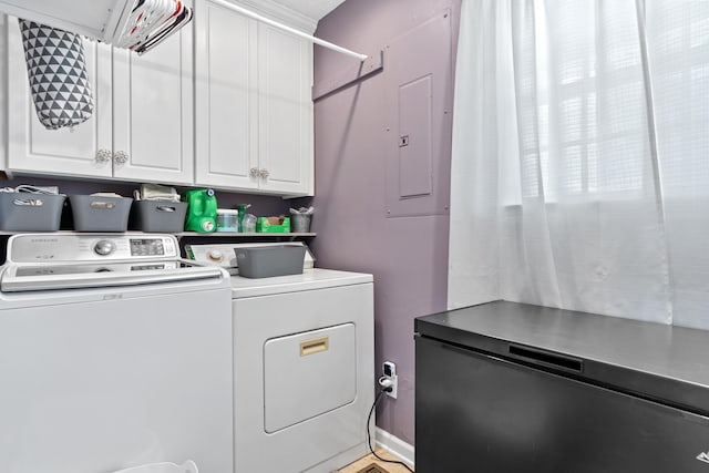 clothes washing area featuring washing machine and clothes dryer and cabinet space