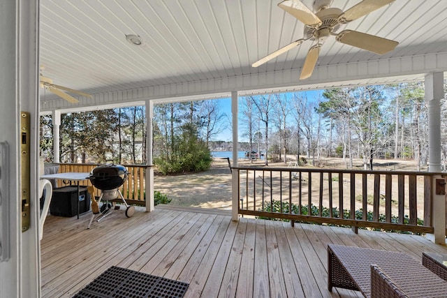 wooden deck with a grill, a ceiling fan, and a water view