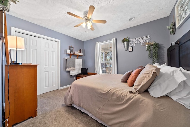 bedroom featuring a ceiling fan, a textured ceiling, a closet, carpet, and baseboards