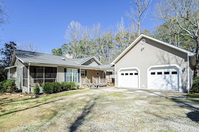 single story home featuring driveway, a chimney, a garage, and a sunroom