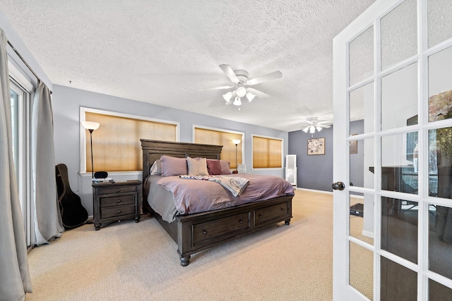 carpeted bedroom featuring a ceiling fan, baseboards, and a textured ceiling