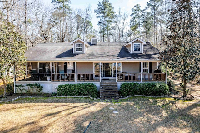 view of front of home with a porch, a front lawn, and a chimney