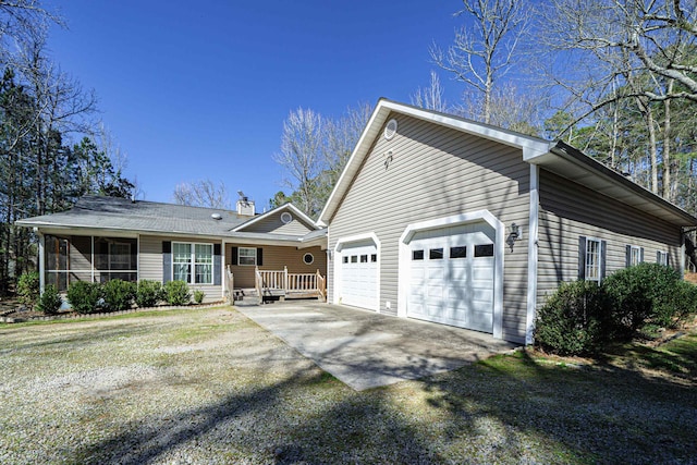 ranch-style home with a sunroom, driveway, and a chimney