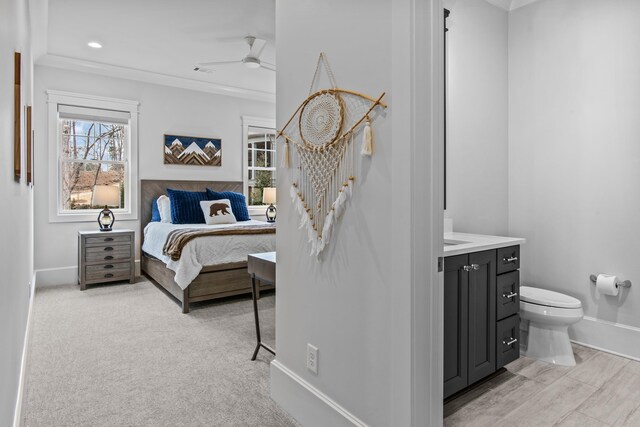 bedroom with crown molding and light colored carpet