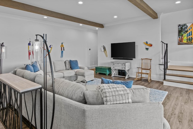 living room with wood-type flooring, ornamental molding, water heater, and beamed ceiling