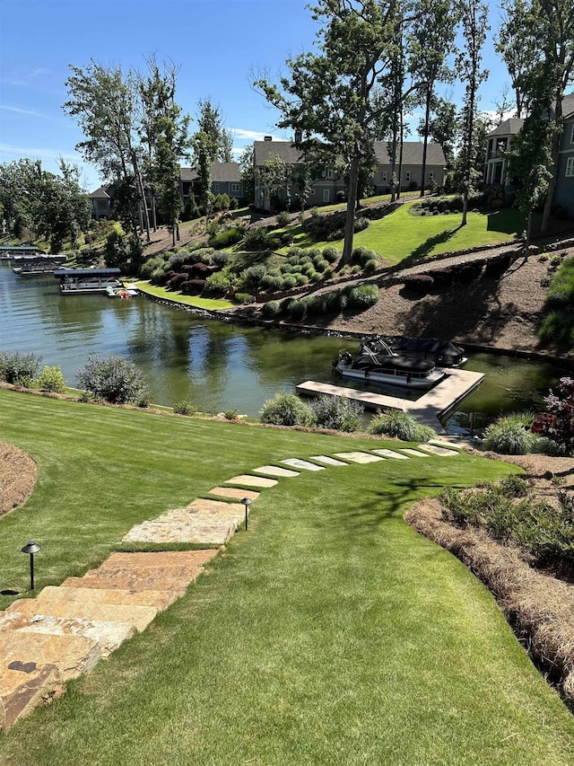 view of community featuring a water view and a lawn