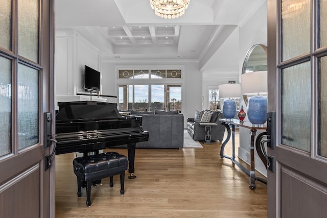 entryway with coffered ceiling, light wood-type flooring, ornamental molding, beamed ceiling, and a towering ceiling