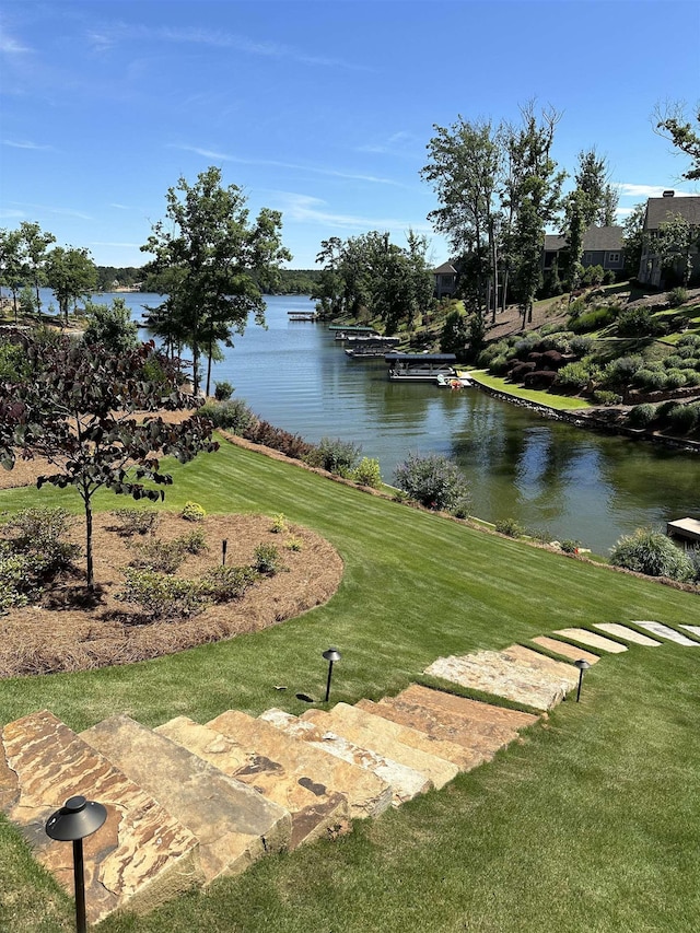 view of community featuring a water view and a lawn