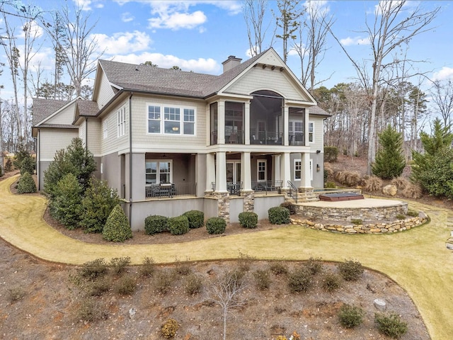 view of front facade featuring a front yard, a sunroom, and a patio