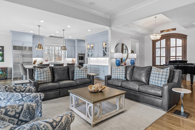 living room with french doors, crown molding, and light wood-type flooring