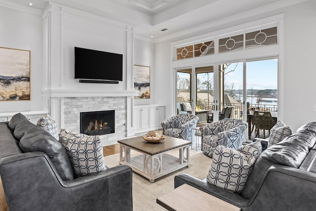 living room with a fireplace, light hardwood / wood-style flooring, and ornamental molding